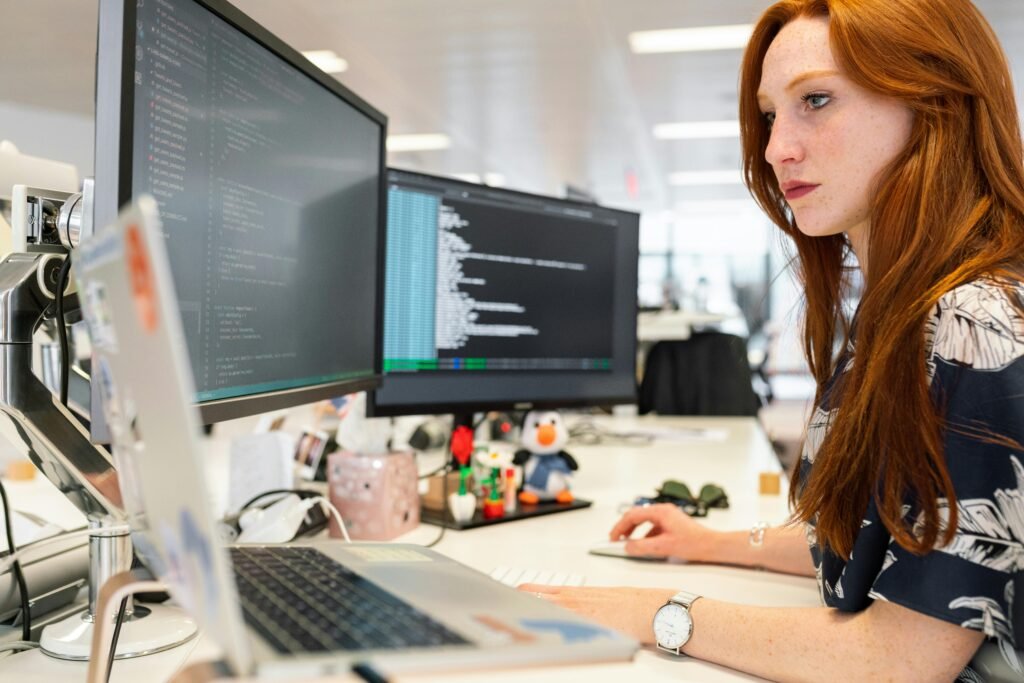 Web developer at a digital agency coding a client’s website, working on front-end design and functionality as part of a larger project team.